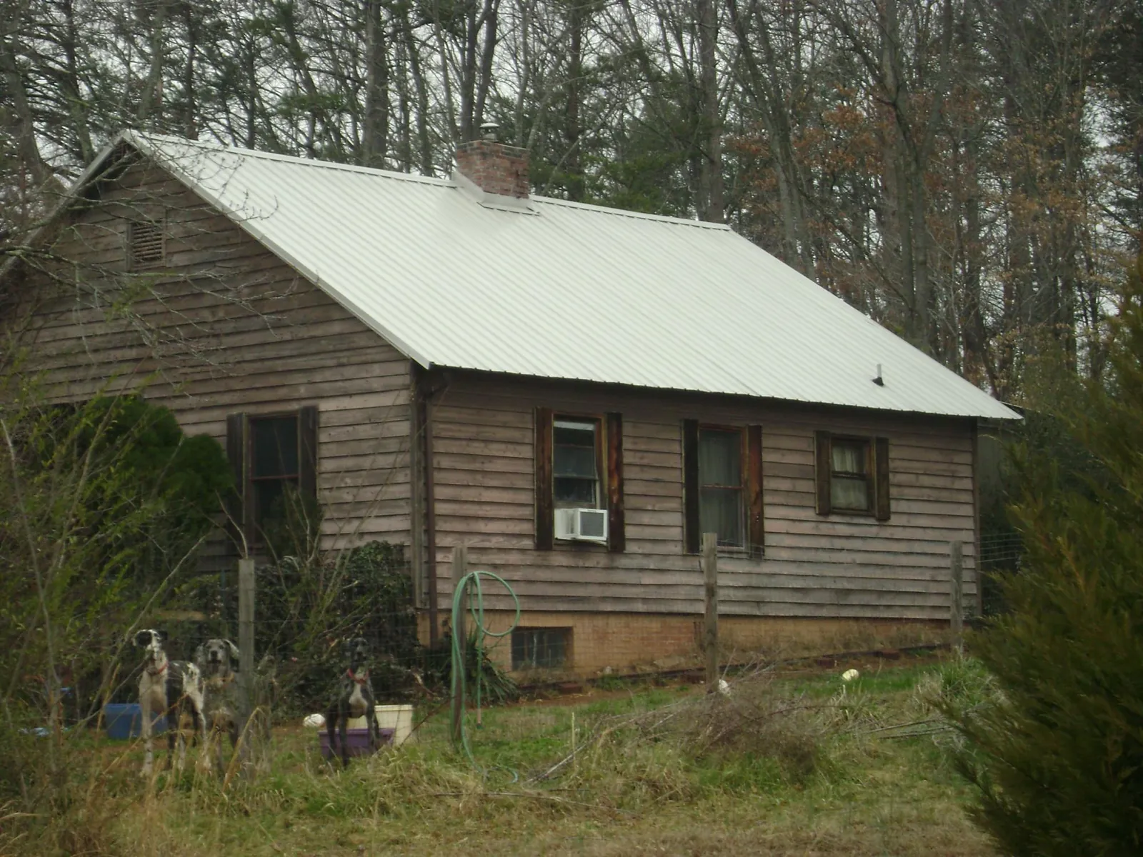White metal roof on an old wood sided farmhouse, from a Metal Roof Installation job in Spring Grove